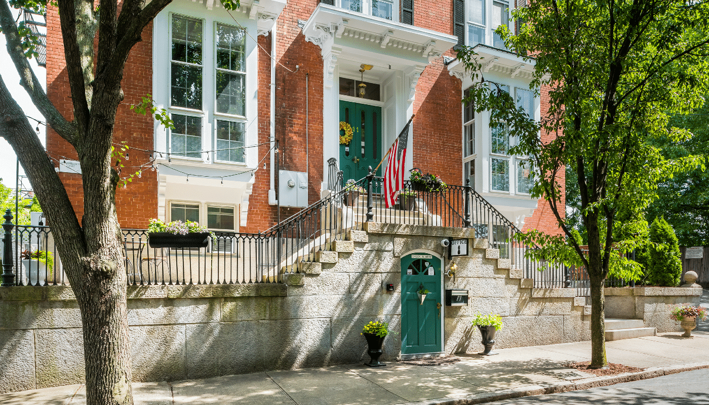 Front view of entryways showcased by bright flowers and a wreath.