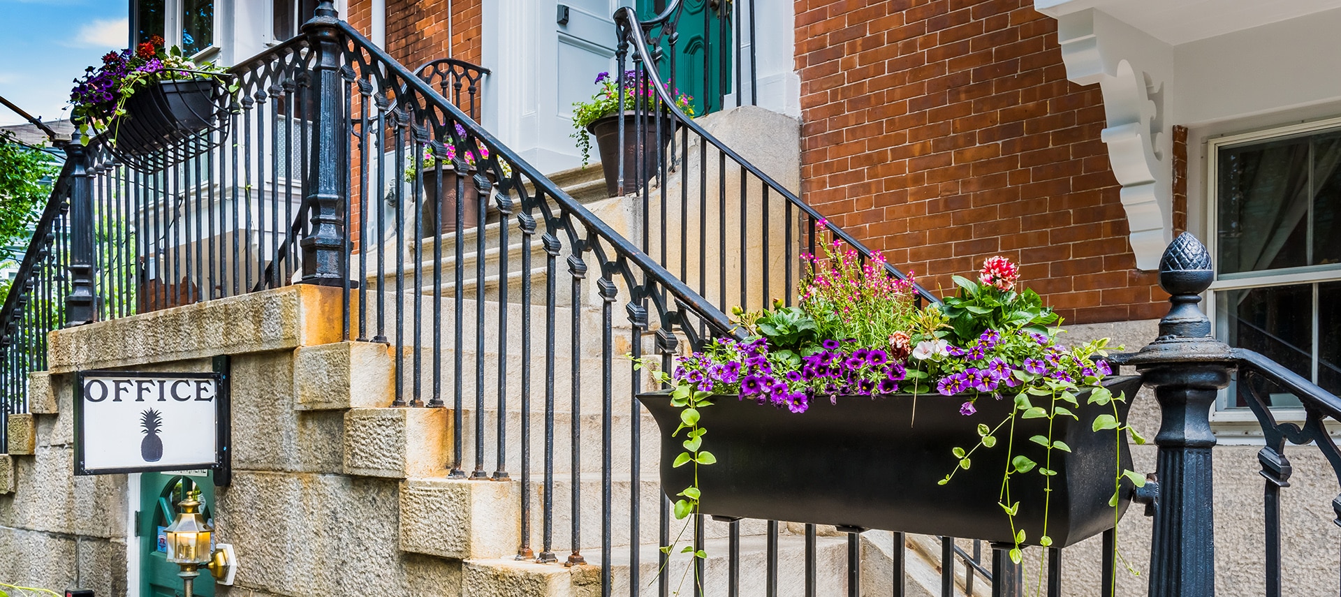 Beautiful flower boxes hanging on a black railing above the office entryway.