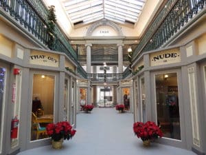 An indoor shopping mall corridor lined with holiday poinsettias. 