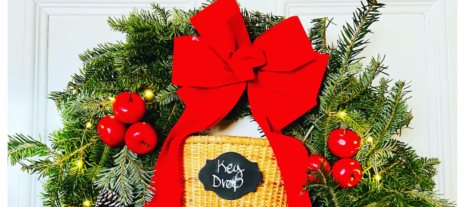 Christmas wreath with a big red bow and warm glowing lights.