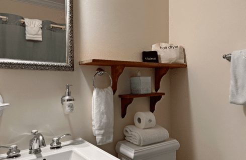 A bathroom with a sink, mirror, and a toilet.