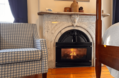 A marble fireplace and a chair.