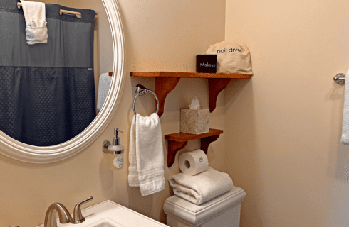 A bathroom with a sink, mirror, and toilet.