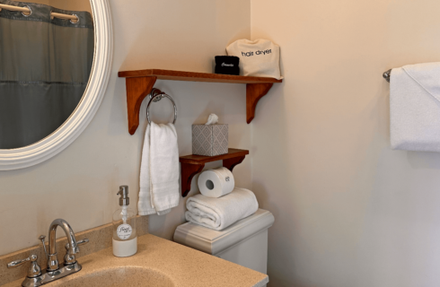 A bathroom with a sink, mirror, and toilet.