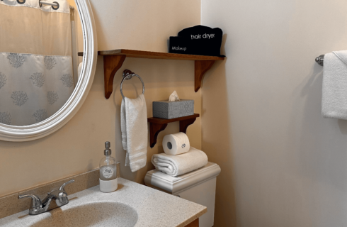 A bathroom with a sink, mirror, and toilet.