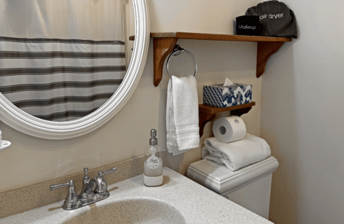 A bathroom with a sink, mirror, and toilet.