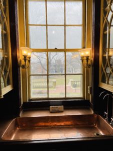A large window placed above a copper sink in the butlers pantry.