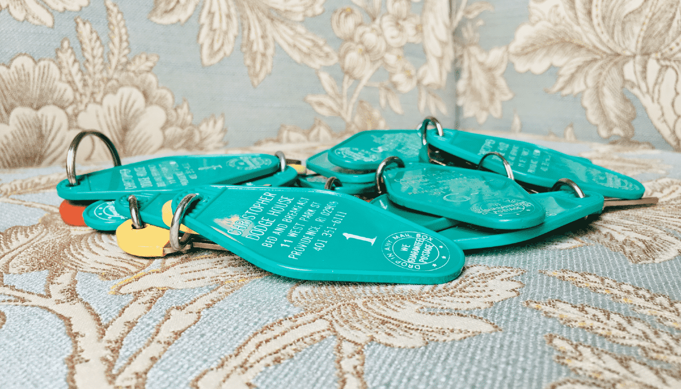 A pile of green keys to the inn taken on an upholstered backdrop.