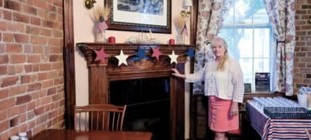 Monica Hopton, owner of Christopher Dodge House, standing in the historic dining room of the Providence bed and breakfast.