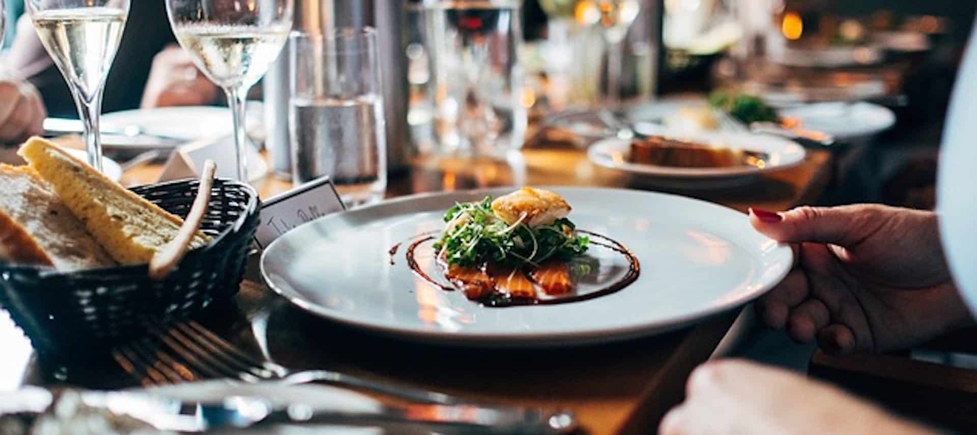 A white plate with a nicely piled salmon and greens.