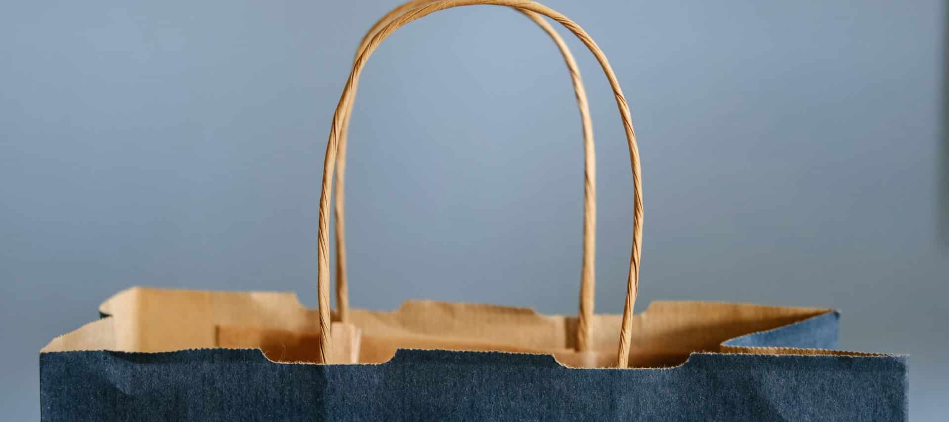 Blue paper shopping bag with handles.