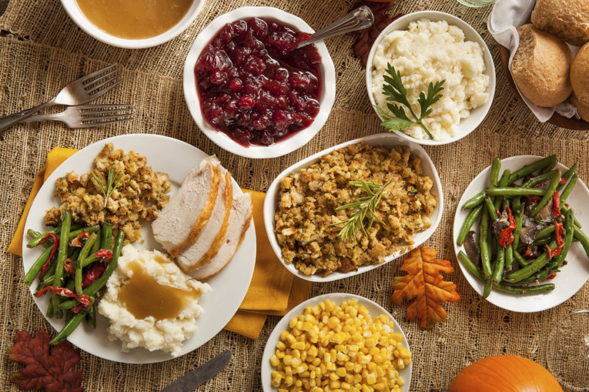 Table with pates full of vegetables and chicken for Thanksgiving Dinner.