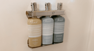 A triple soap station filled with shampoo, conditioner, and shower gel.