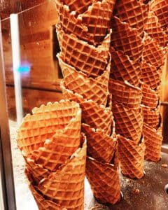 Stacked homemade waffle cones waiting to be filled with ice cream.