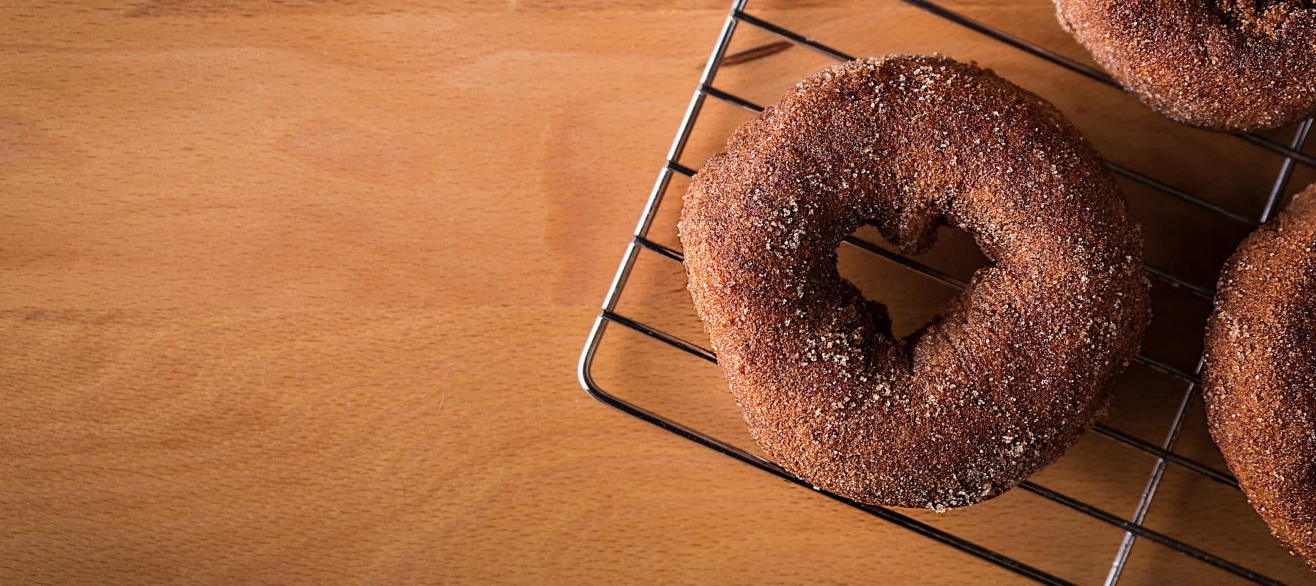 Cinnamon sugar donut on a wire cooling rack.