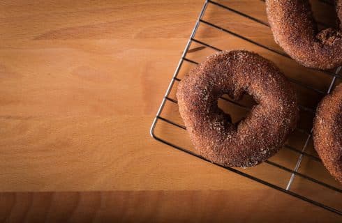 Cinnamon sugar donut on a wire cooling rack.