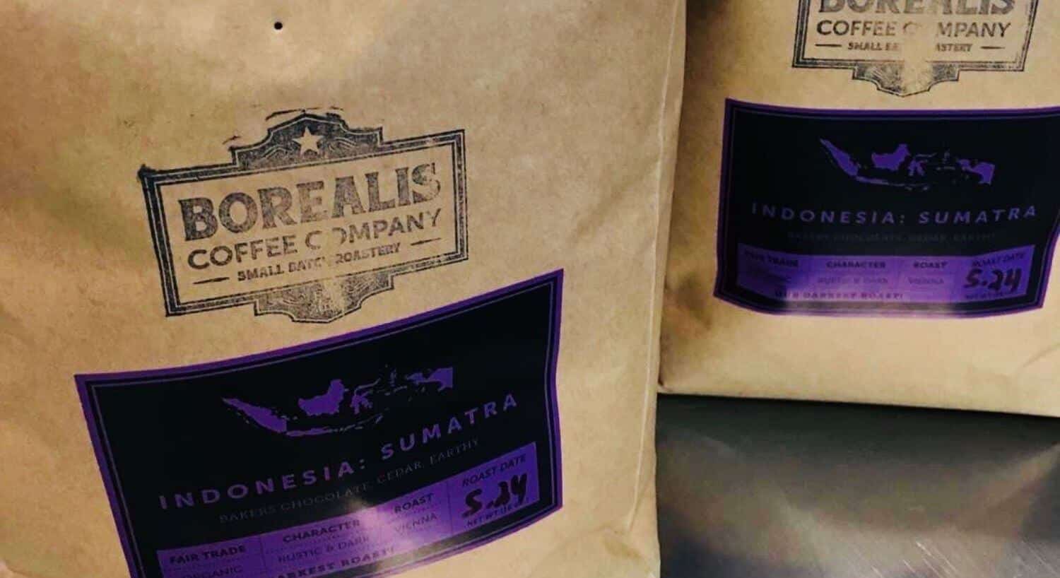 Two paper bags of Borealis coffee with purple labels. 