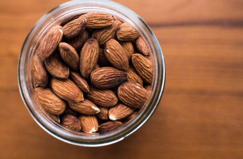 Almonds in a glass jar placed on a tabletop.